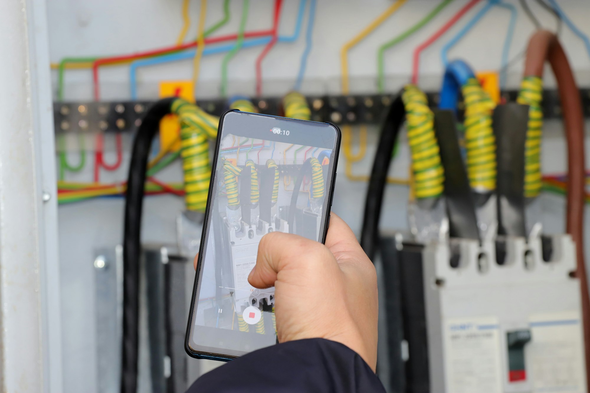 Technician Doing Meter Reading on Kilowatt hour electric meter using Smartphone, screen says day and